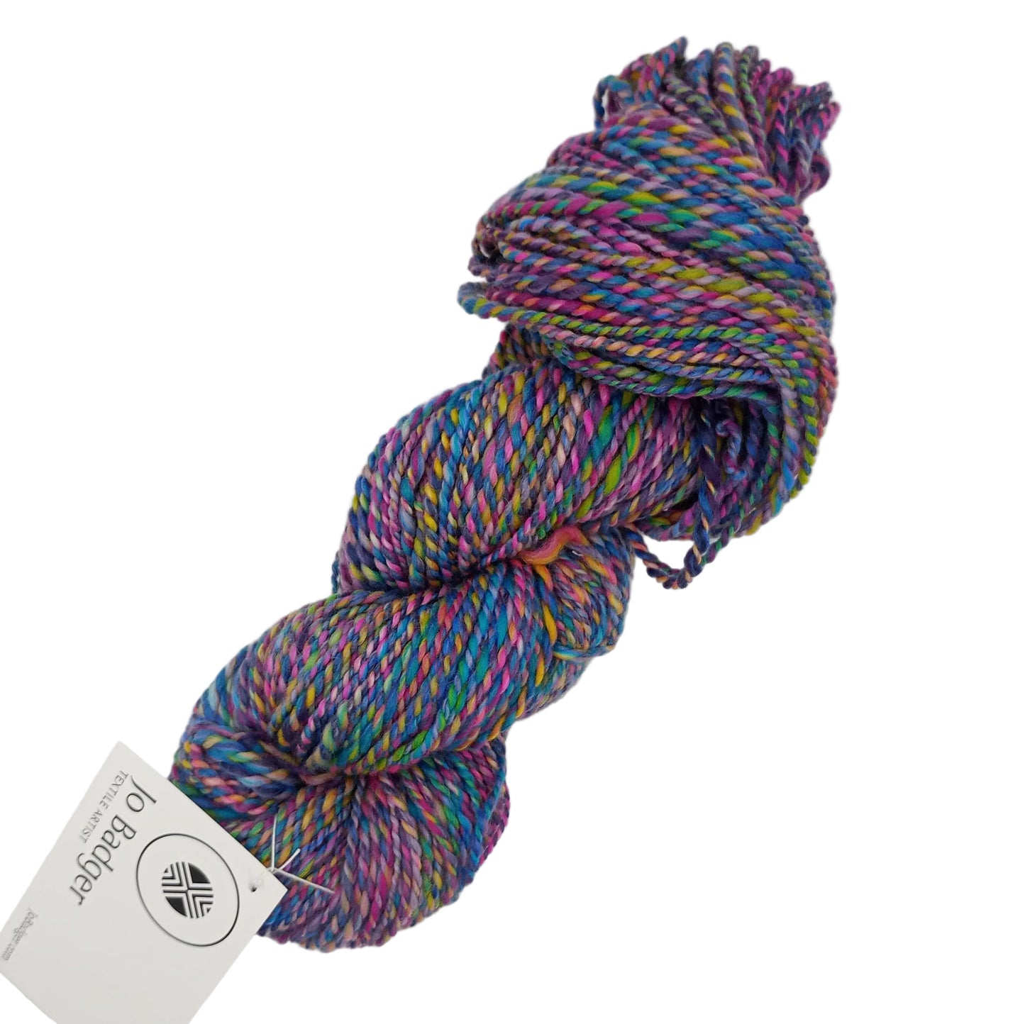A skein of variegated yarn with purple, blue, green, and pink threads, featuring a white tag from Jo Badger, set against a plain white background.